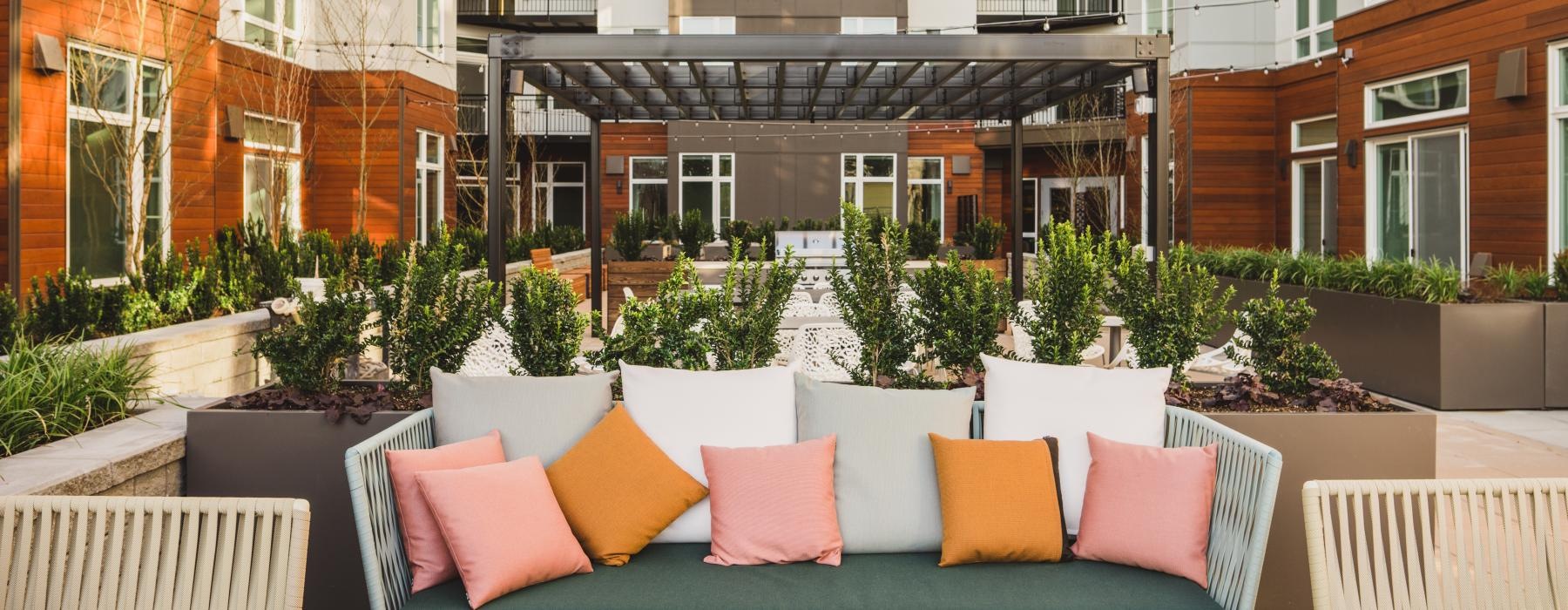 a patio with chairs and tables in front of a building