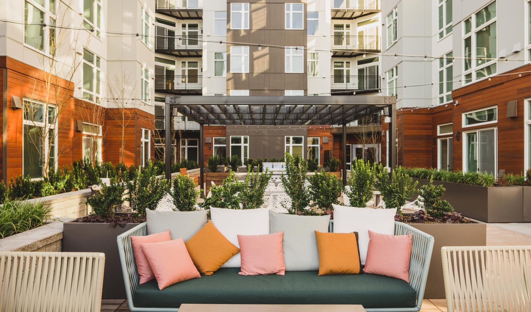 a patio with chairs and tables in front of a building