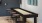 a table with stools and a tv in a room with a black wall